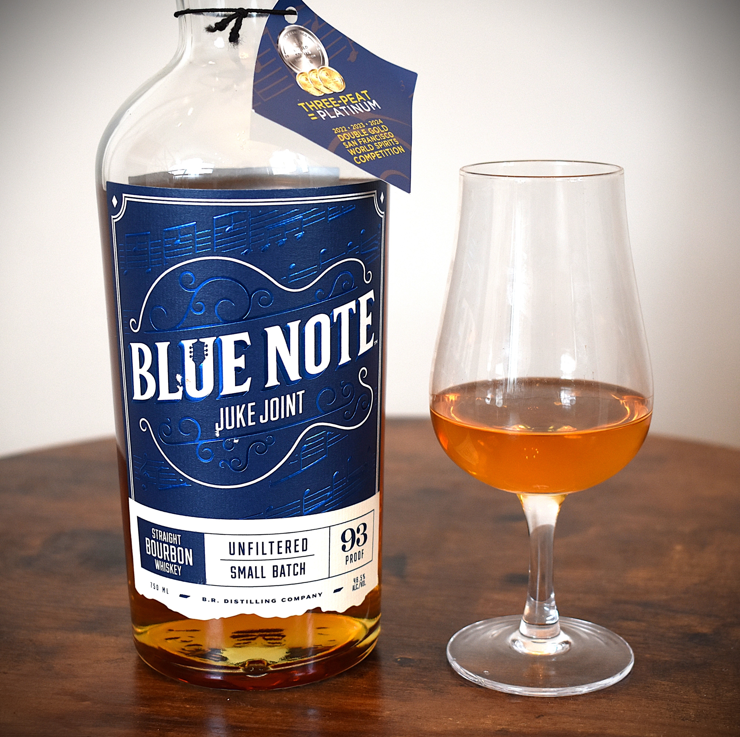 Blue Note Juke Joint Bourbon with the bourbon poured into a copita glass next to it