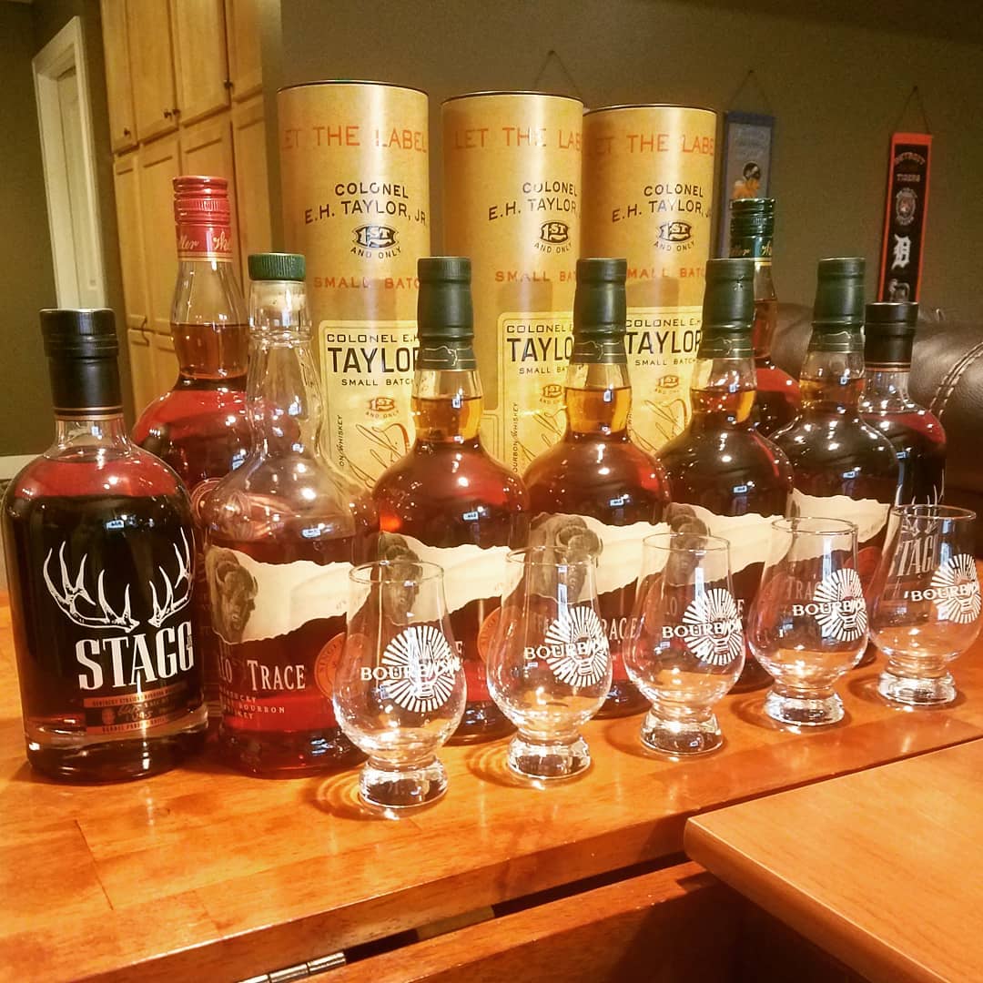 Variety of buffalo trace distllery bourbons on a counter with bourbinsane glasses in the front of all the bottles